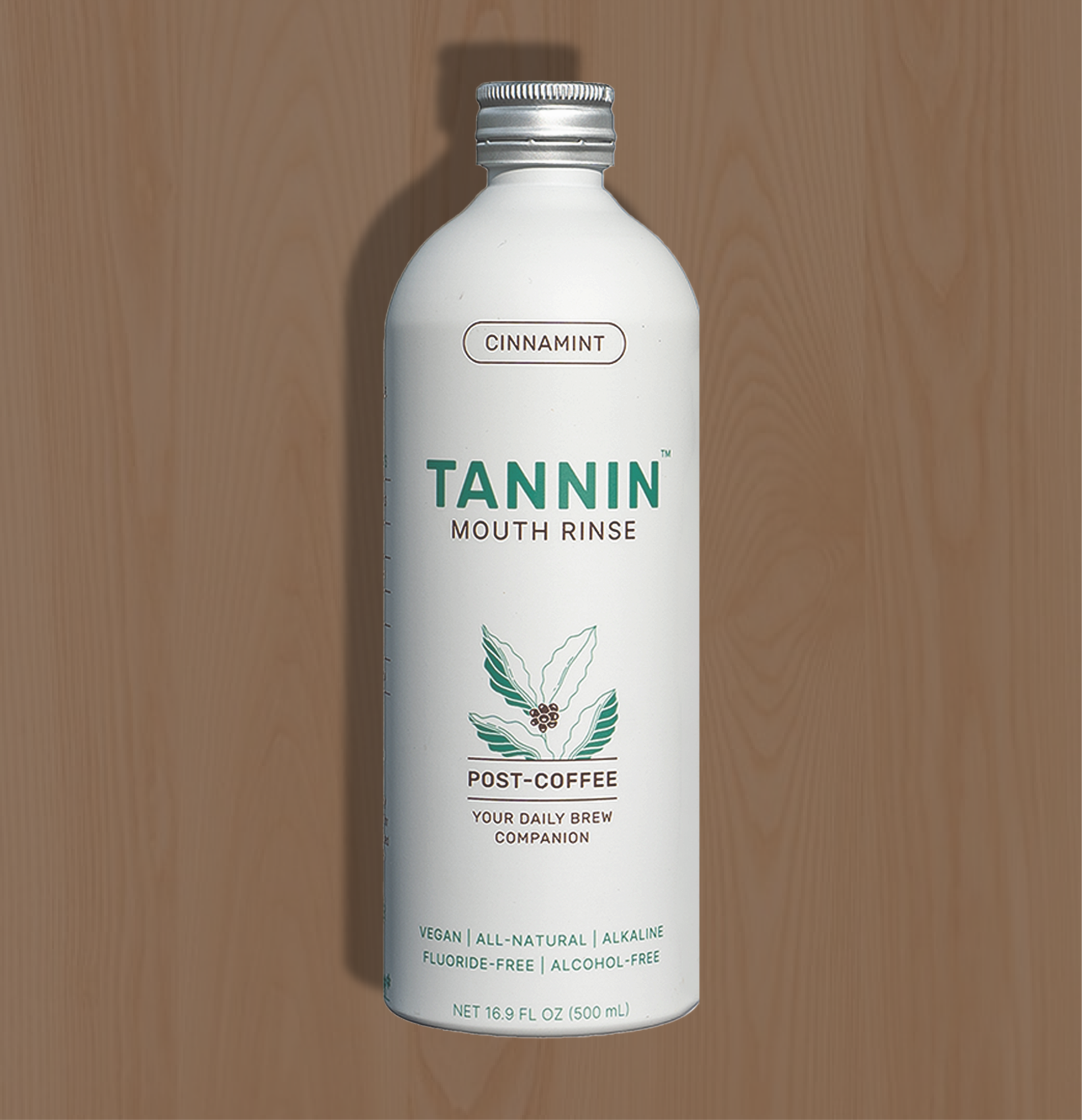 Large Tannin mouth rinse bottle with a cinnamon mint flavor, designed for at-home use, shown against a wooden background. Ideal for coffee lovers seeking a refreshing oral care routine at home.