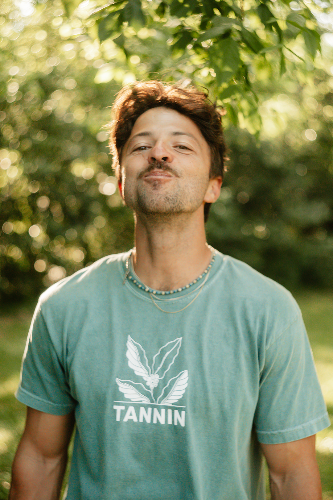 Man in a Tannin shirt swishing the rinse in his mouth, following the second step: swish for 15-30 seconds.